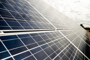 Close-up of solar panels under a cloudy sky, capturing renewable energy; no recognizable landmarks or historical buildings are visible.